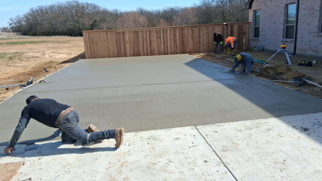 Crew finishing a 22x30 concrete slab for a metal building project