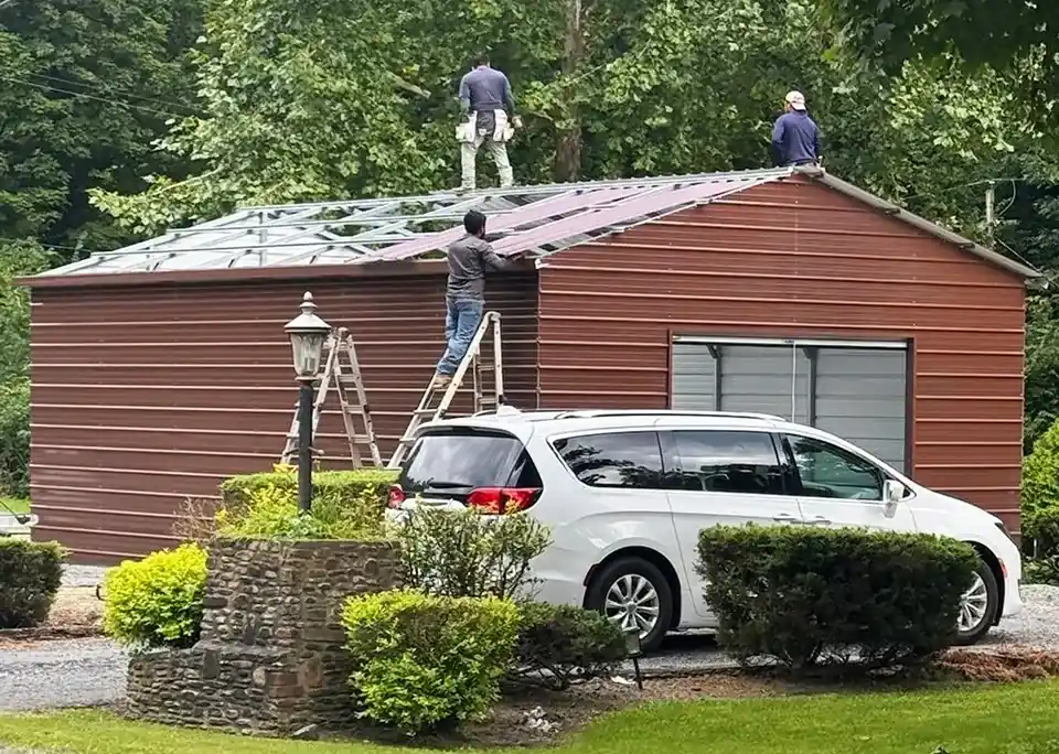 Crew installing roof panels on a residential metal building